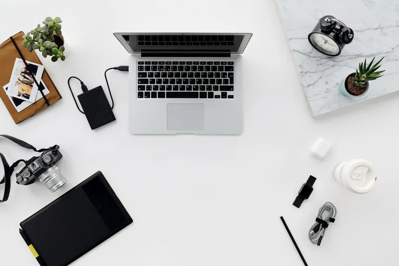 Ein aufgeräumter Schreibtisch mit Laptop und externer Festplatte, symbolisiert zuverlässige Datensicherung.