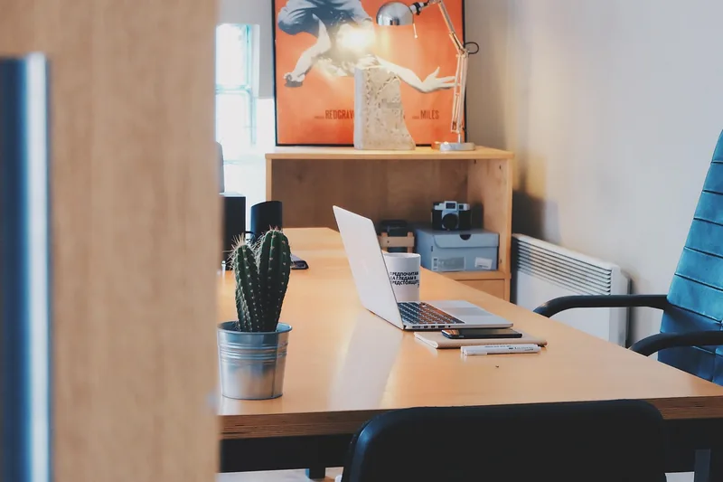 Modernes Home-Office mit Schreibtisch, Bildschirm und einem gut integrierten, stilvollen Bürostuhl.