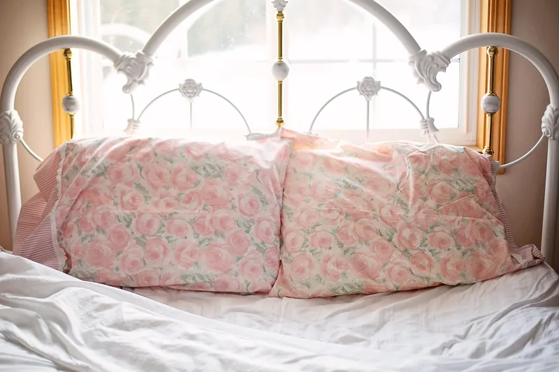 Ein ruhiges Schlafzimmer mit aufgeschütteltem Bett, das erholsamen Schlaf und Komfort symbolisiert.