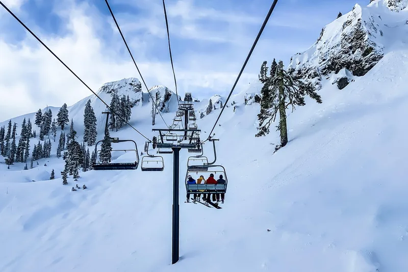Atemberaubende Winterlandschaft mit Skifahrern auf der Piste, die Skijacken tragen und den Schnee genießen.