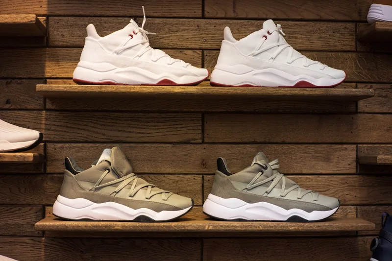 Mehrere frisch gereinigte, strahlende Sneaker stehen ordentlich auf einem Regal im modernen Lifestyle-Kontext.
