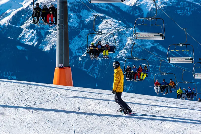 Eine Person trägt Snowboard-Boots im Schnee, bereit für das nächste Abenteuer auf der Piste.