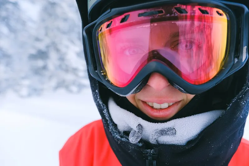 Nahaufnahme der verspiegelten Linse einer Snowboardbrille, detailreiche Darstellung.