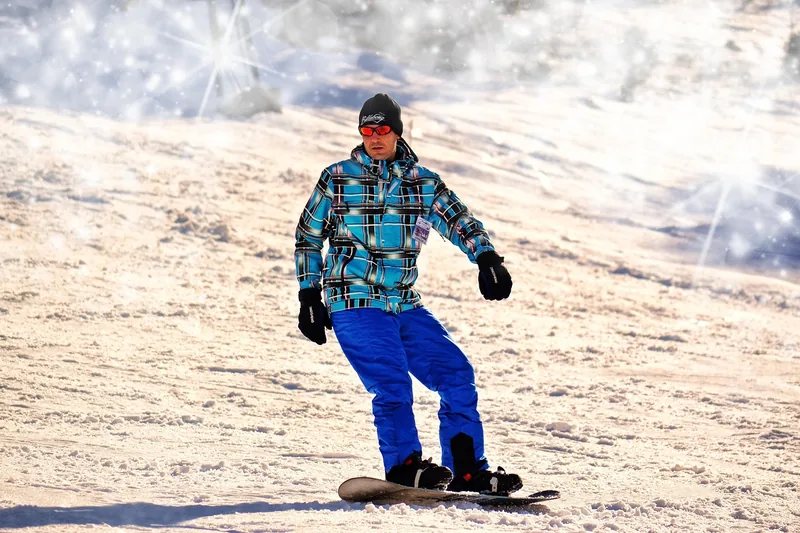 Ein Skifahrer trägt eine Snowboardbrille über seiner Korrektionsbrille auf der Piste.
