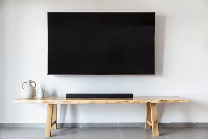 Eine schlanke, schwarze Soundbar für TV Geräte, isoliert vor neutralem Hintergrund.