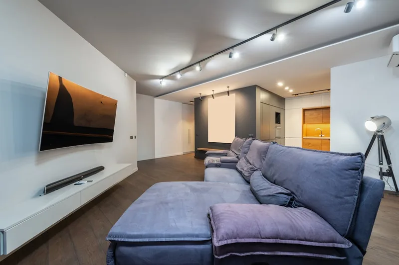 Modernes Wohnzimmer mit eingeschaltetem TV und Soundbar, schafft ein beeindruckendes Heimkinoerlebnis.