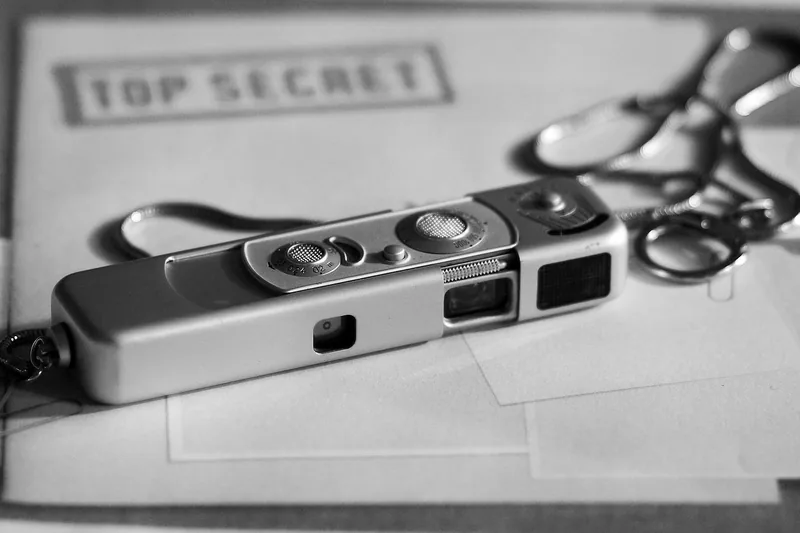 Detailaufnahme der winzigen Linse und des Gehäuses einer unauffälligen Spionagekamera.
