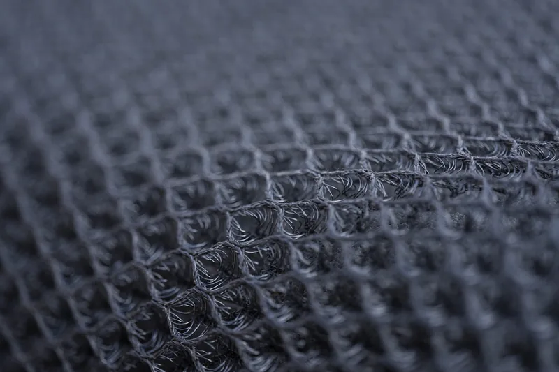 Makroaufnahme des atmungsaktiven Stoffes einer Damen Sport Leggings, zeigt die feine Webart und Nähte.