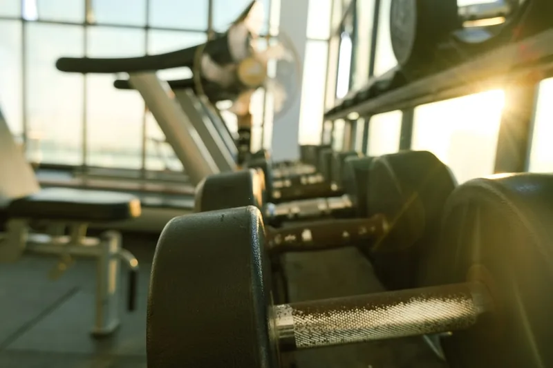 Motivierende Fitnessstudio-Szene mit verschiedenen Trainingsgeräten und Sportzubehör im unscharfen Hintergrund.