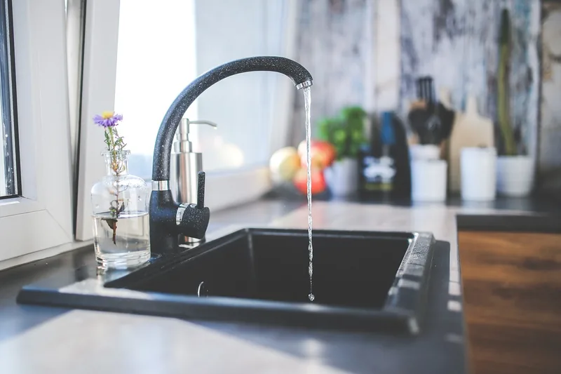 Eine glänzende, hochwertige Spültischarmatur mit minimalistischem Design auf neutralem Hintergrund.