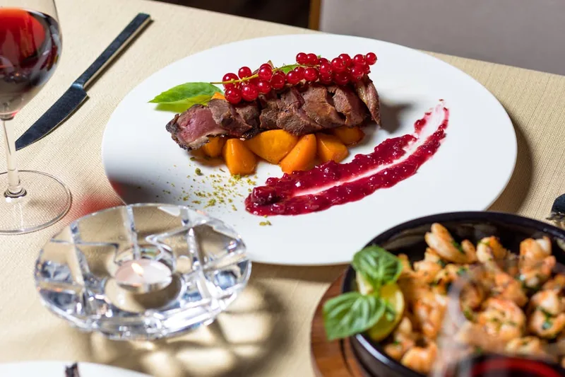Ein elegant gedeckter Esstisch mit vorbereiteten Steaks und passendem Steakbesteck für ein Festmahl.