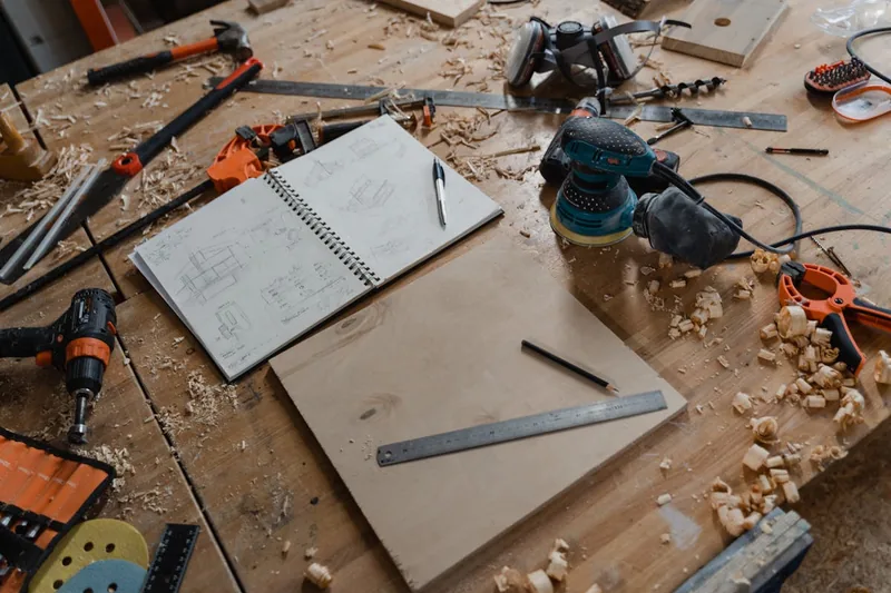Eine aufgeräumte Werkstattszene mit einem fertiggestellten Holzprojekt und Werkzeugen im Hintergrund, ohne Person.