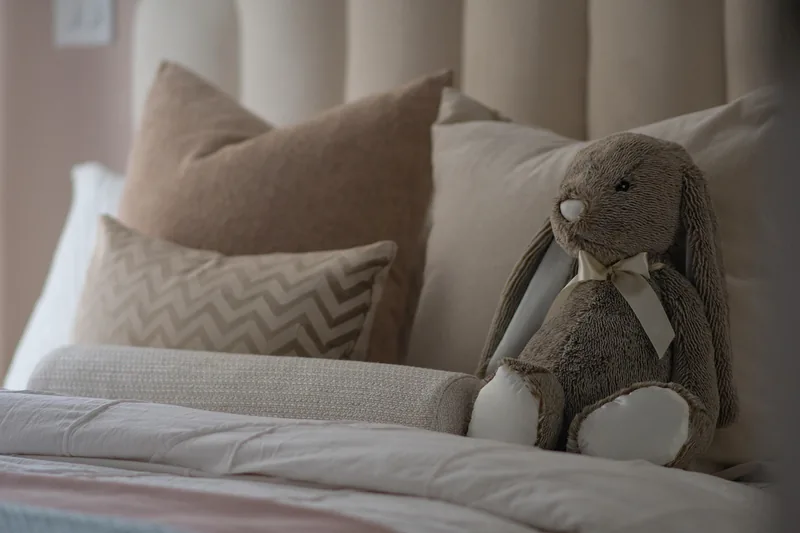 Ein weiches Stimmungskuscheltier liegt gemütlich auf einem Bett, um positive Stimmung zu verbreiten.