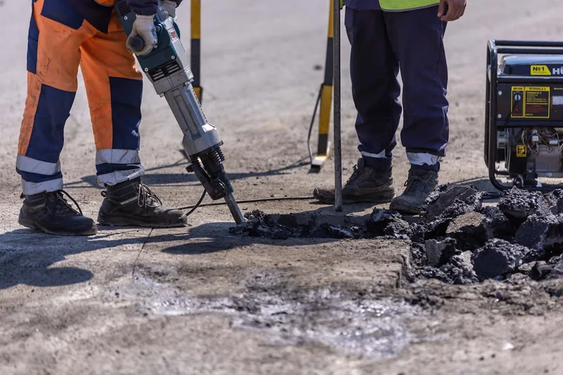 Ein mobiler Stromerzeuger liefert auf einer Baustelle im Hintergrund zuverlässig Energie für Werkzeuge.