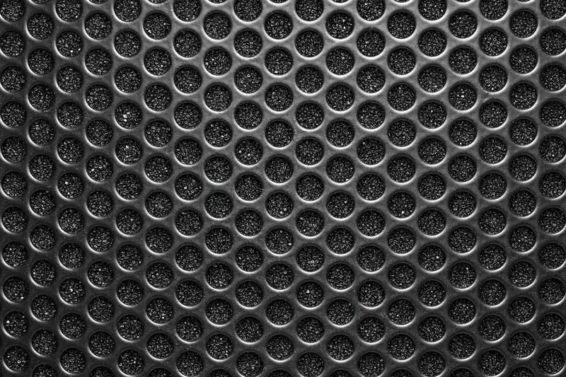 Detailaufnahme der feinen Gitterstruktur eines Surround-System-Lautsprechers mit elegantem Finish.