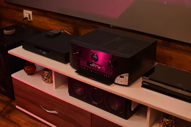 Eine Person konfiguriert die Einstellungen eines Surround-Sound-Receivers im Heimkino.