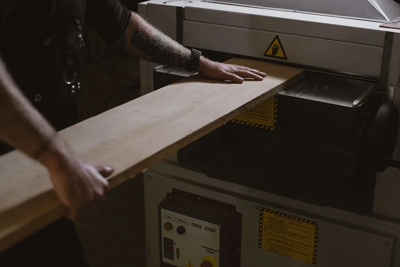 Ein sauber geschnittenes Stück Holz liegt auf einer Werkbank, umgeben von Werkzeugen, symbolisiert präzise Ergebnisse.