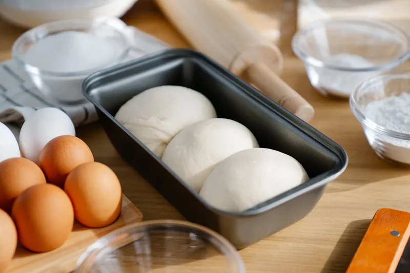 Warme Küchenszene mit Backzutaten und dem Ergebnis frischen Brotes, Backen als Leidenschaft.