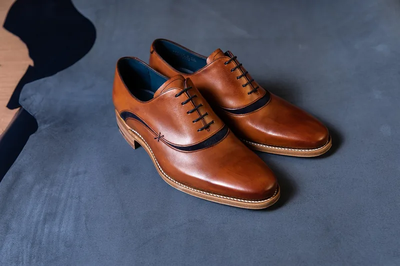 Ein Paar hochwertige Trachtenschuhe für Herren, elegant präsentiert auf neutralem Hintergrund.