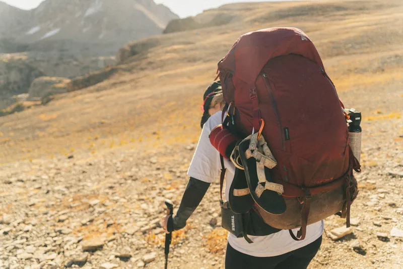 Ein moderner Trekkingrucksack in neutralem Ton, frontal dargestellt, isoliert vor hellem Hintergrund.