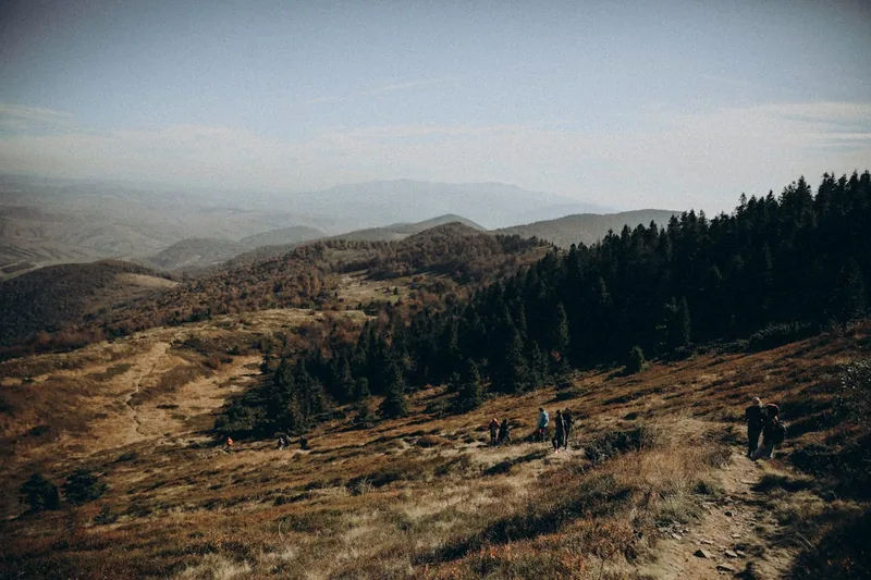 Weitläufige Berglandschaft mit einem Wanderweg, der eine einladende Atmosphäre für Trekkingschuhe schafft.