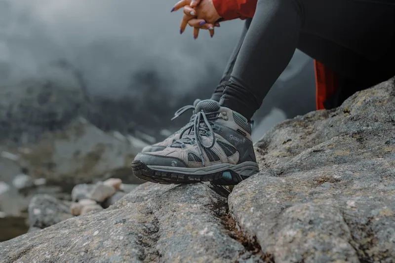 Ein Wanderer in Trekkingschuhen steigt einen Pfad hinauf, demonstriert Tragekomfort.