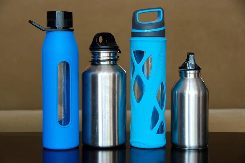 Hochwertige BPA-freie Trinkflasche aus verschiedenen Materialien im Studio-Produktfoto, neutraler Hintergrund.