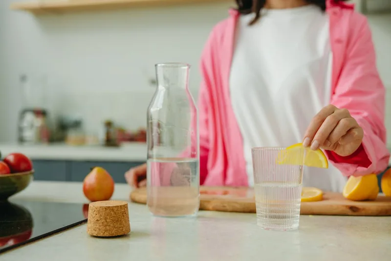 Ein Küchentisch mit frischem Obst und Trinkflasche, symbolisiert einen gesunden Lebensstil zu Hause.