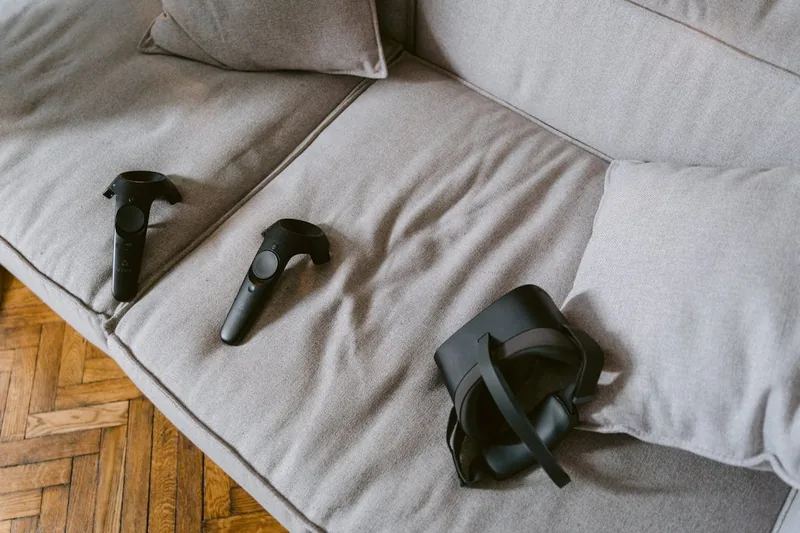 Modernes Wohnzimmer mit VR-Brille und Controllern auf Couchtisch, bereit für Gaming-Session.