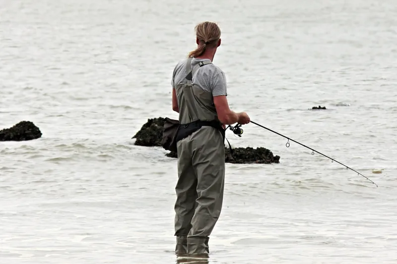 Angler nutzt eine starke Wallerrute am Flussufer.