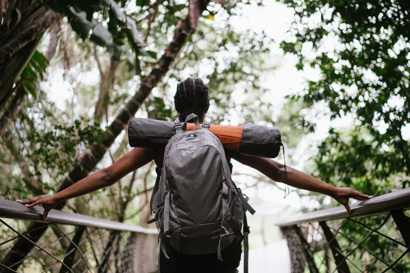 Eine Person schnallt den Hüftgurt eines Wanderrucksacks fest, um die Passform zu optimieren.