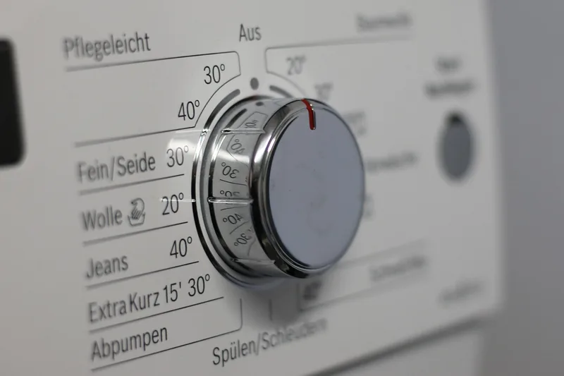 Nahaufnahme des Bedienfelds eines Waschtrockners mit Programmwahl und digitaler Anzeige für einfache Bedienung.