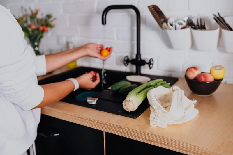 Helle und moderne Küche mit frischem Obst und sauberem Trinkwasser.