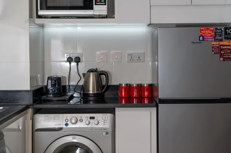 Ein eleganter Edelstahl-Wasserkocher steht auf einer modernen Küchenarbeitsplatte beim Frühstück.