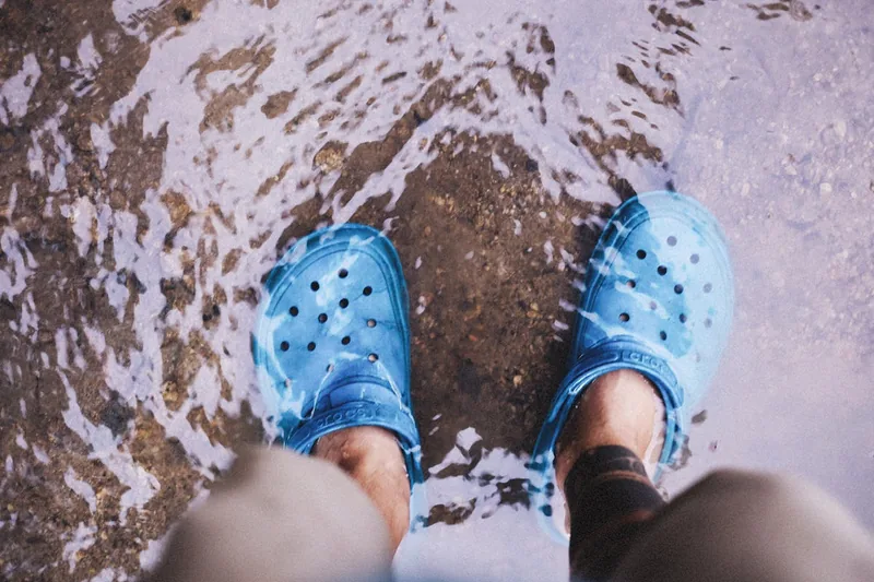Person trägt Wasserschuhe beim Gehen im Wasser