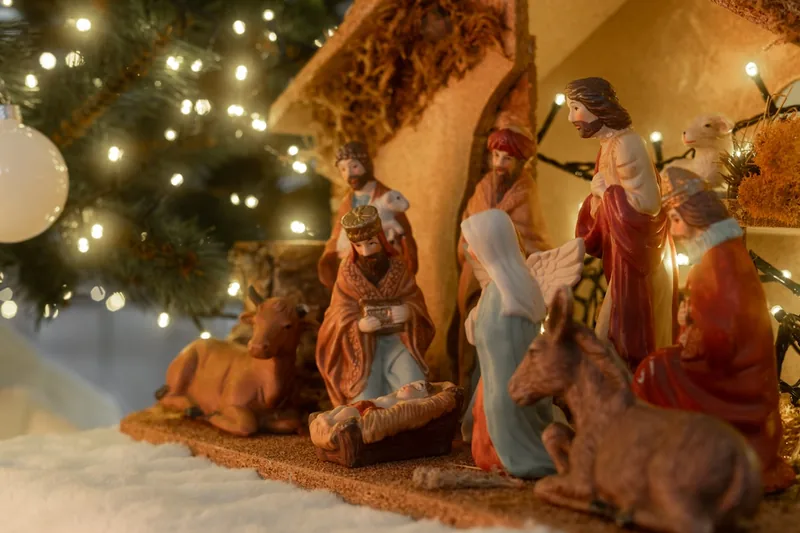 Weihnachtliche Wohnzimmer-Atmosphäre mit einer beleuchteten Weihnachtskrippe als Herzstück.
