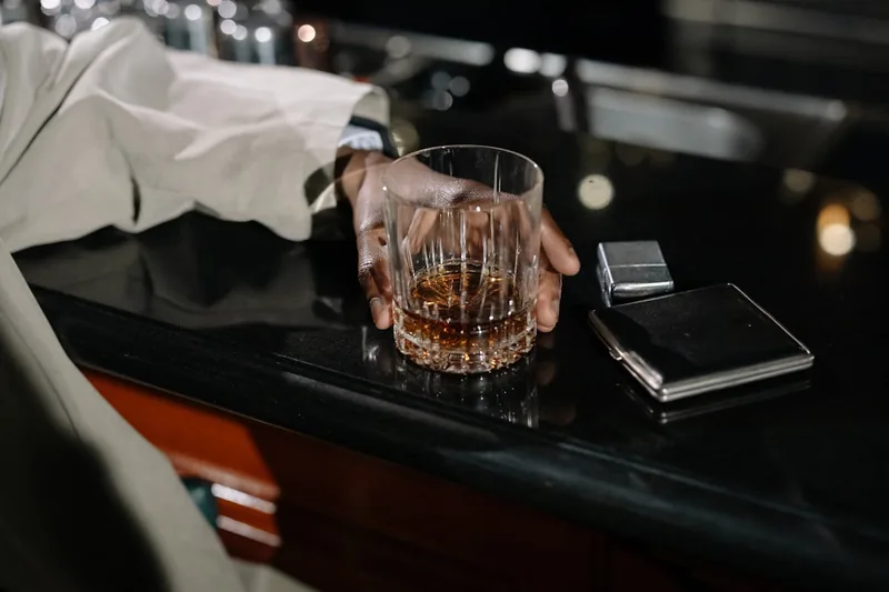 Eine Hand gießt sorgfältig Whisky in ein Glas, symbolisiert den Genuss und die Anwendung.