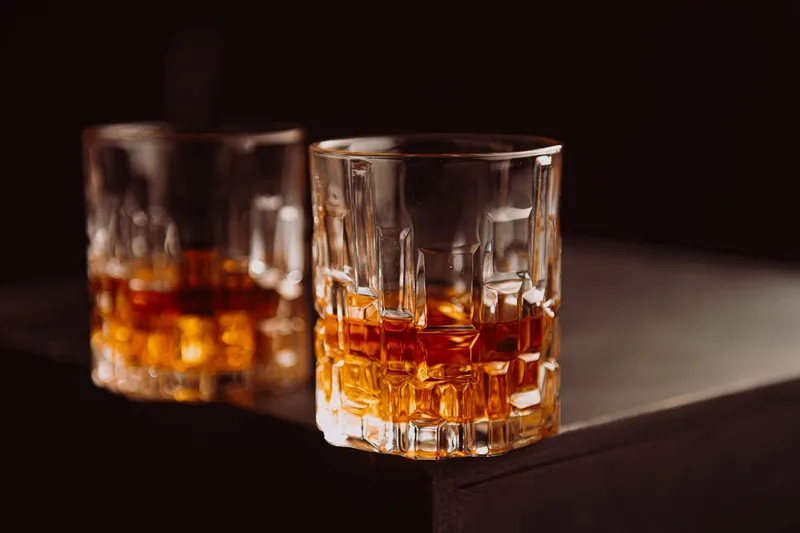Hochwertiges, leeres Whiskyglas mit klarem Kristallschliff vor neutralem Hintergrund.