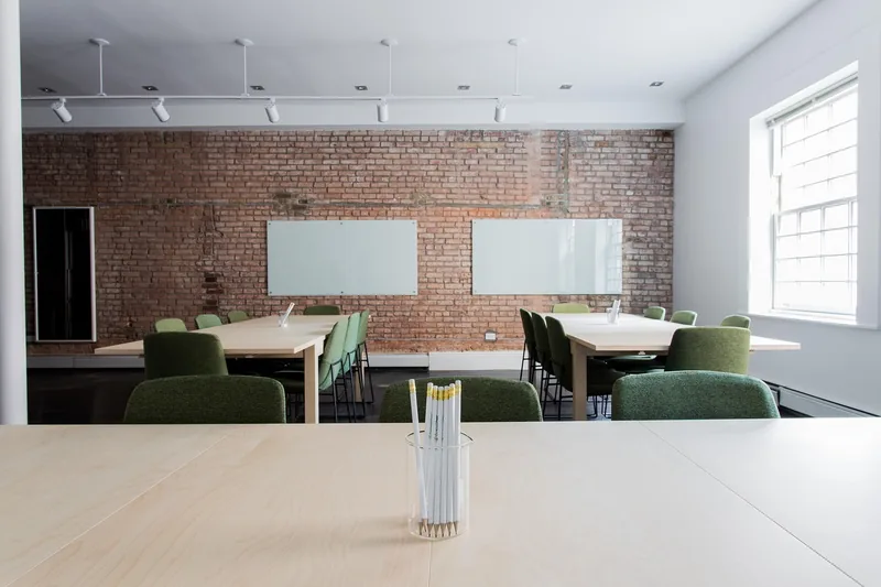 Helles, modernes Büroumfeld mit Whiteboard im Hintergrund, das Zusammenarbeit symbolisiert.