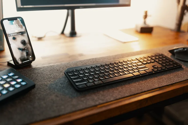 Eine Person tippt auf einer kabellosen Tastatur, Hände auf den Tasten, für präzises und komfortables Arbeiten.