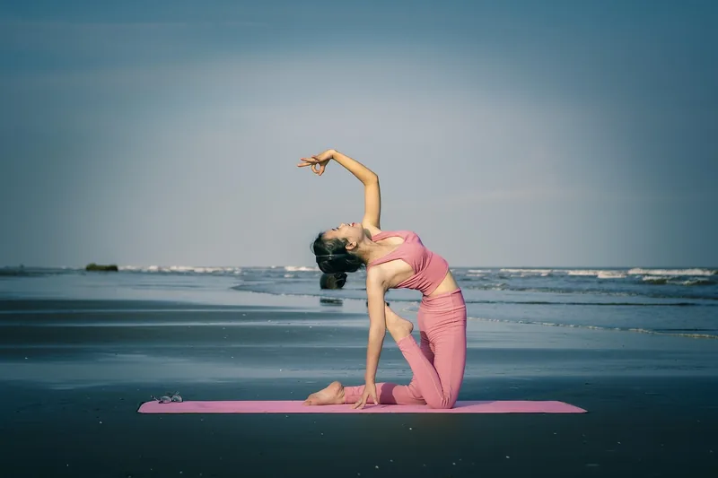 Eine Person in einer flexiblen Yoga Hose, die eine Stretching-Pose ausführt und die Bewegungsfreiheit betont.