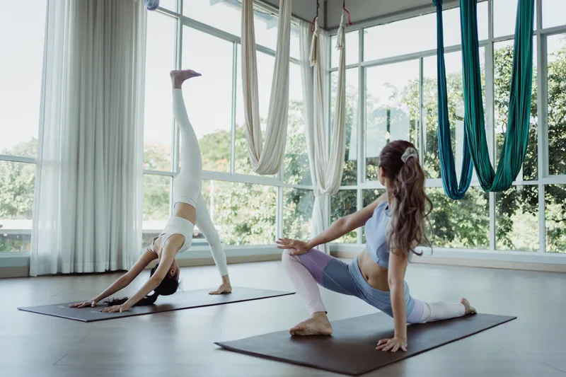 Ruhige und einladende Yoga-Studio-Atmosphäre mit einer Matte und gedämpftem Licht, das Wohlbefinden symbolisiert.