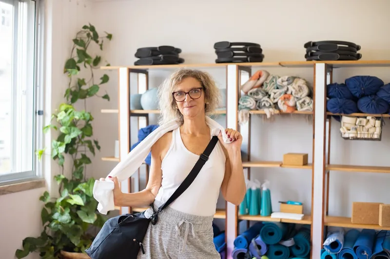 Eine stilvolle Yogatasche steht in einem ruhigen Yogastudio, bereit für eine Reise oder den Kursbesuch.